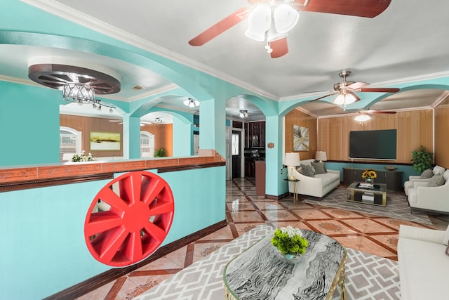 living room featuring an inviting chandelier, ornamental molding, and wood walls