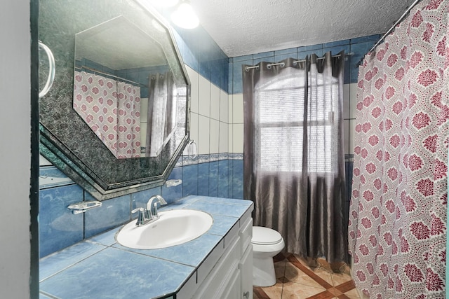 bathroom with tile patterned floors, walk in shower, vanity, a textured ceiling, and toilet