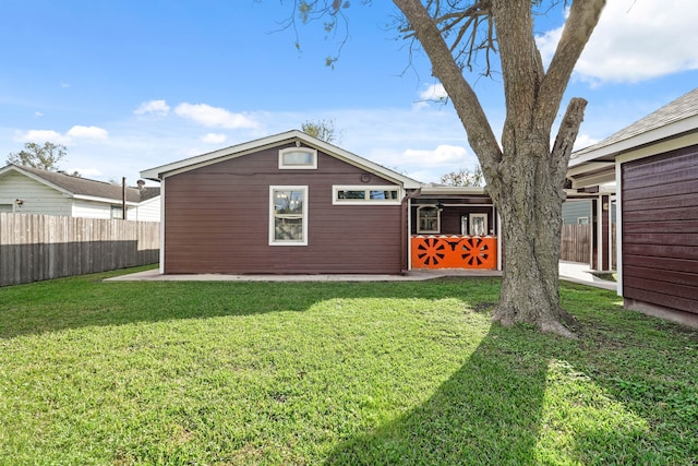 rear view of property with a lawn