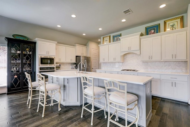 kitchen featuring white cabinets, stainless steel appliances, and a spacious island