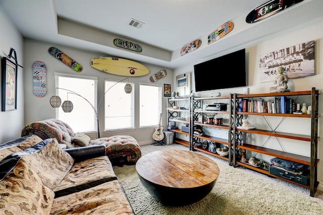 living room with carpet flooring and a tray ceiling