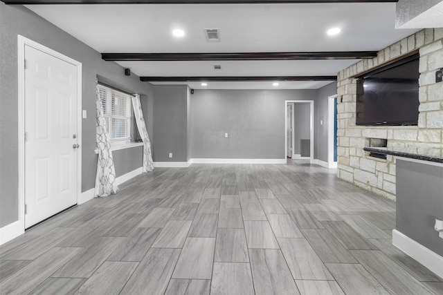 unfurnished living room with beam ceiling