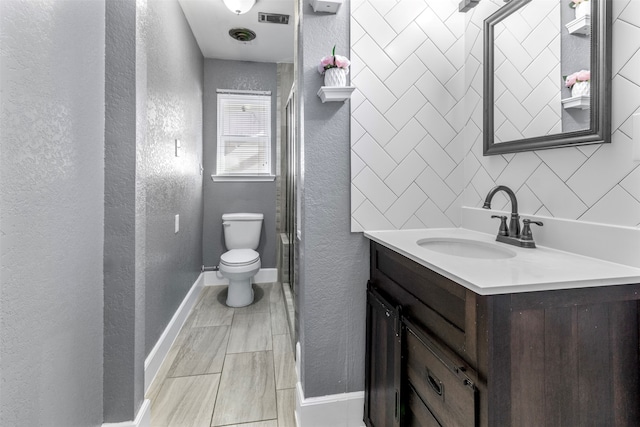 bathroom with vanity, toilet, and a shower