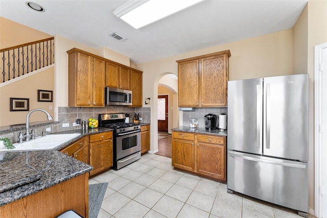 kitchen featuring stainless steel appliances, a sink, visible vents, and brown cabinets