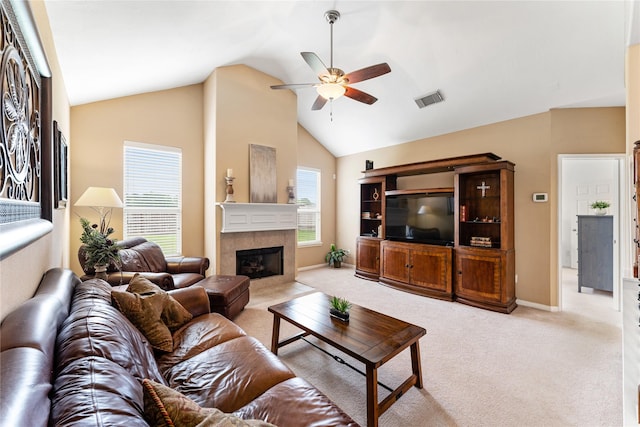 living area featuring light carpet, baseboards, visible vents, a ceiling fan, and a fireplace