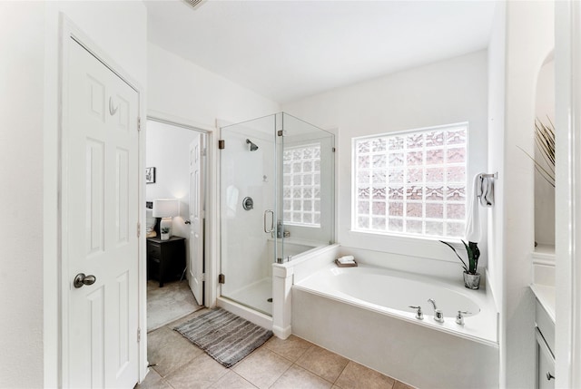 bathroom featuring a shower stall, a bath, and tile patterned floors