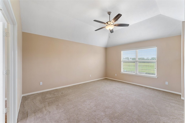 carpeted empty room featuring lofted ceiling, ceiling fan, and baseboards