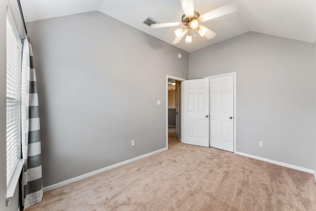 unfurnished bedroom featuring lofted ceiling, carpet flooring, visible vents, and baseboards