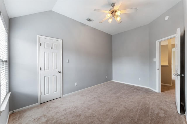 unfurnished bedroom featuring lofted ceiling, carpet, visible vents, and baseboards