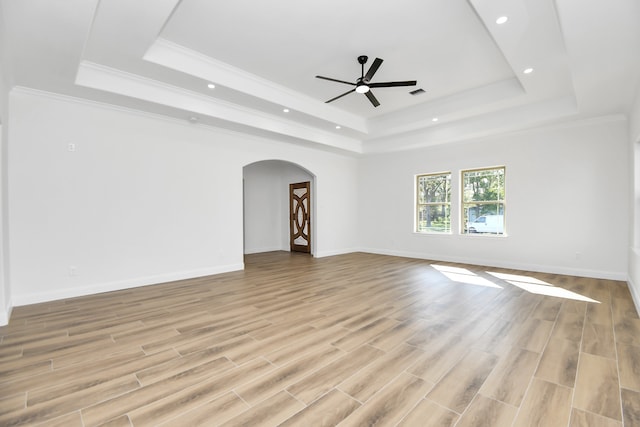 interior space with a tray ceiling, ceiling fan, and light hardwood / wood-style flooring