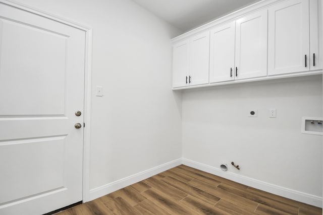 laundry room featuring cabinets, dark wood-type flooring, washer hookup, electric dryer hookup, and gas dryer hookup