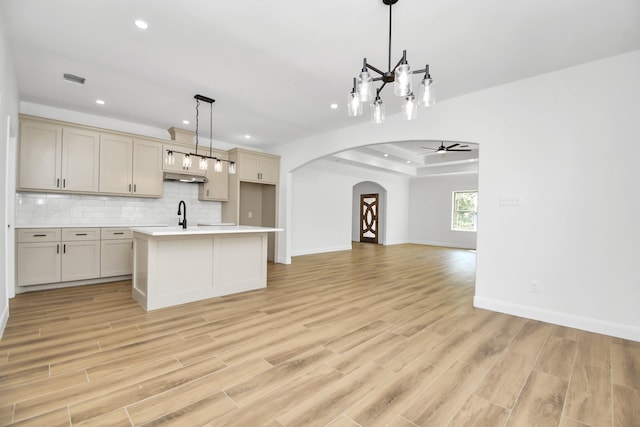 kitchen with ceiling fan with notable chandelier, pendant lighting, and light wood-type flooring