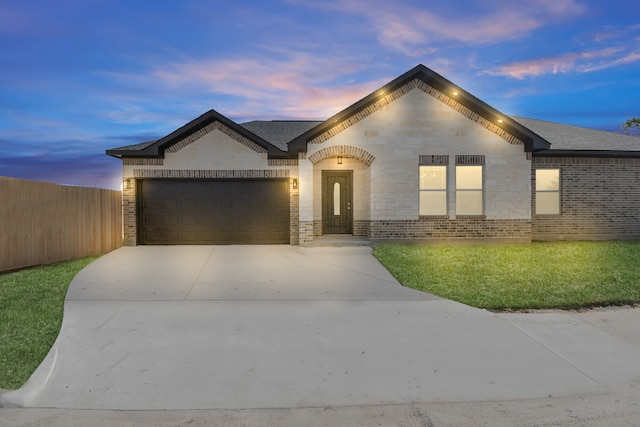 view of front of property with a garage and a lawn