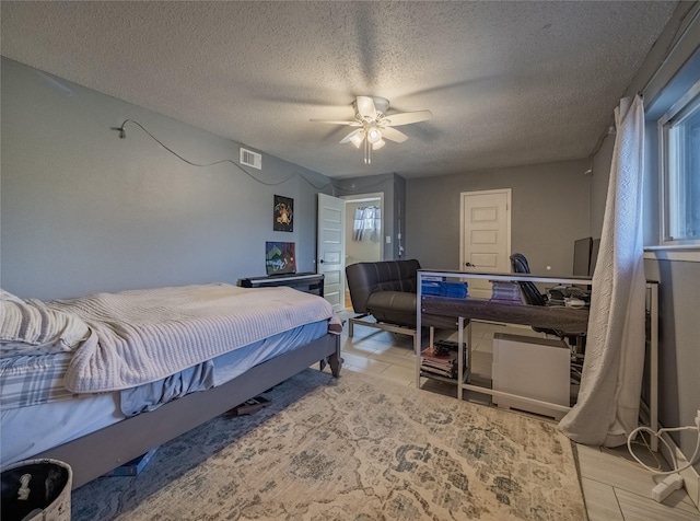 bedroom with a textured ceiling and ceiling fan