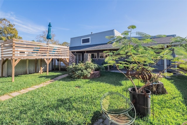 back of house featuring a wooden deck and a yard