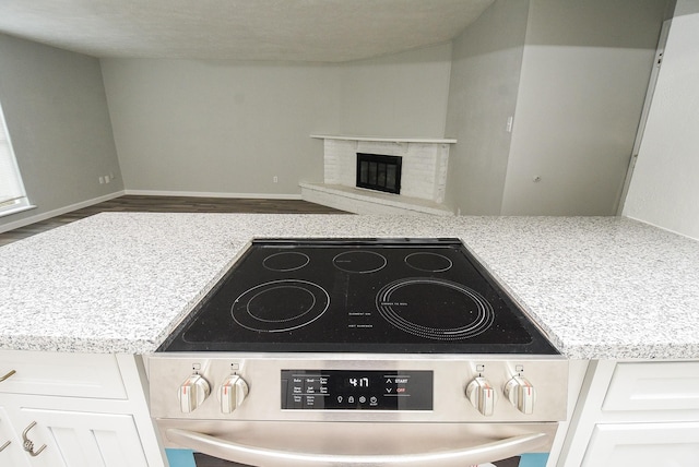 details with white cabinetry, dark wood-type flooring, and stainless steel range with electric cooktop