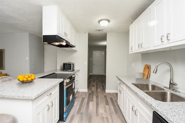 kitchen featuring sink, light hardwood / wood-style flooring, appliances with stainless steel finishes, light stone countertops, and white cabinets