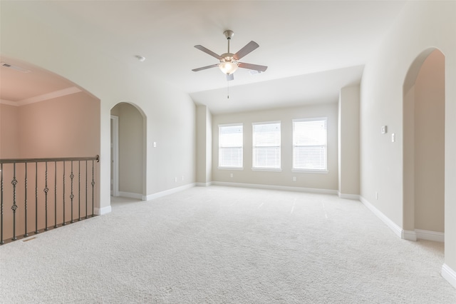 spare room with ceiling fan, ornamental molding, and light carpet