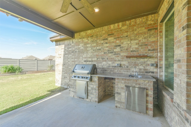 view of patio with area for grilling, a grill, sink, and ceiling fan