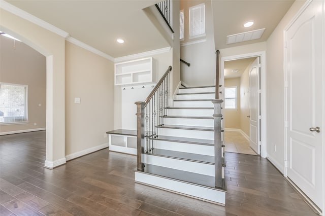 staircase with wood-type flooring and ornamental molding