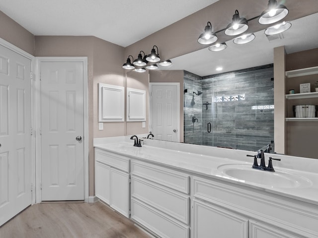 bathroom with hardwood / wood-style flooring, vanity, and a shower with door