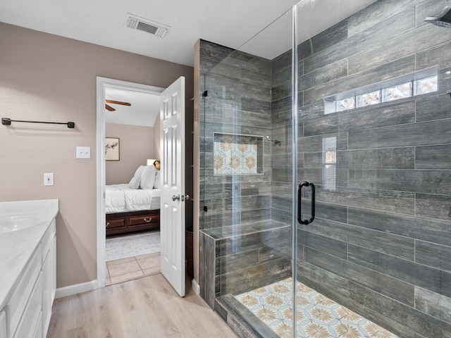 bathroom with ceiling fan, hardwood / wood-style floors, vanity, and an enclosed shower