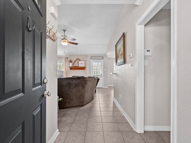 corridor featuring light tile patterned floors and a textured ceiling