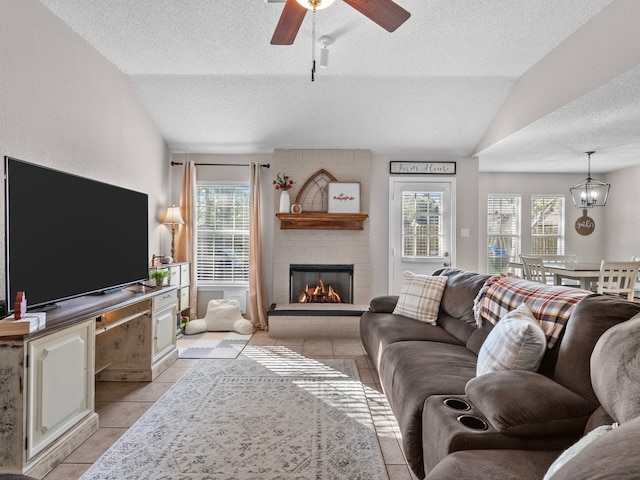 living room featuring a textured ceiling, plenty of natural light, lofted ceiling, and a brick fireplace