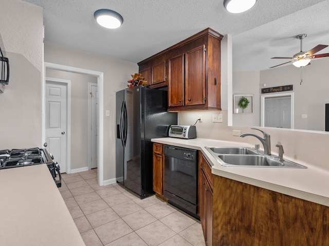 kitchen featuring light tile patterned flooring, a textured ceiling, sink, and black appliances