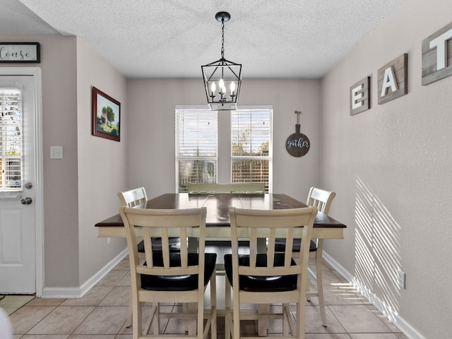 dining space featuring a notable chandelier, light tile patterned floors, a textured ceiling, and a wealth of natural light