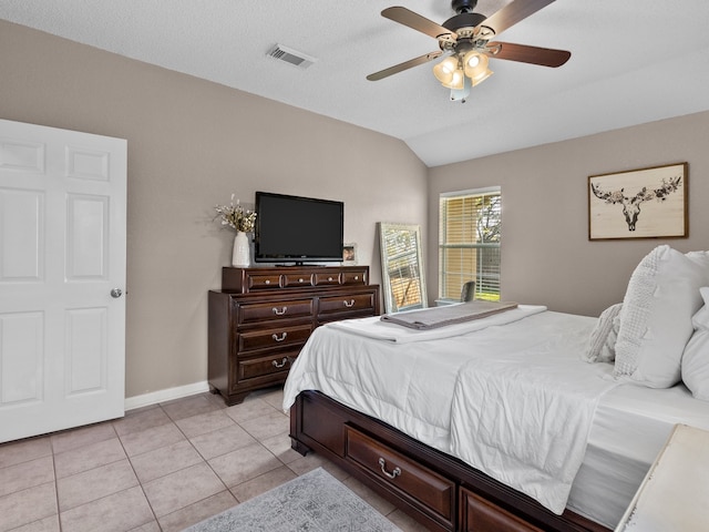 bedroom with ceiling fan, light tile patterned flooring, lofted ceiling, and a textured ceiling