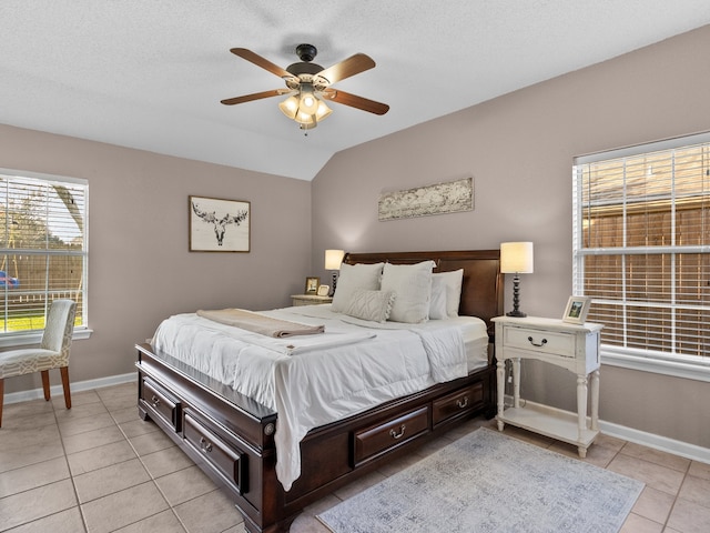 tiled bedroom with a textured ceiling, ceiling fan, and lofted ceiling