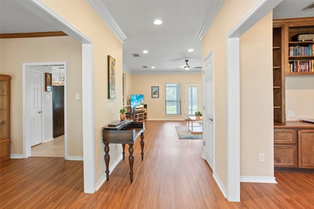 hall featuring ornamental molding and light hardwood / wood-style flooring