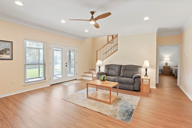 living room with ceiling fan, crown molding, and light wood-type flooring