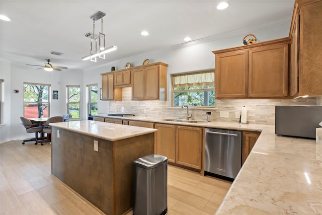 kitchen featuring decorative backsplash, stainless steel dishwasher, sink, a kitchen island, and hanging light fixtures