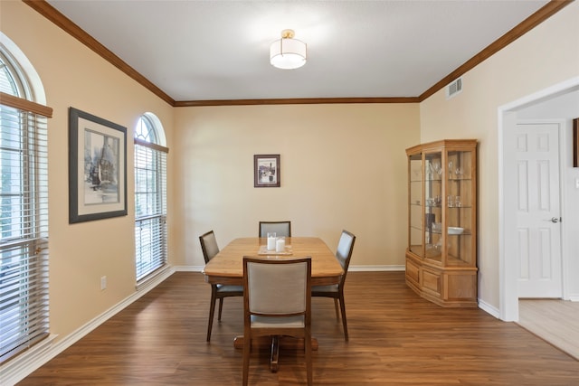 dining space with dark hardwood / wood-style floors and ornamental molding