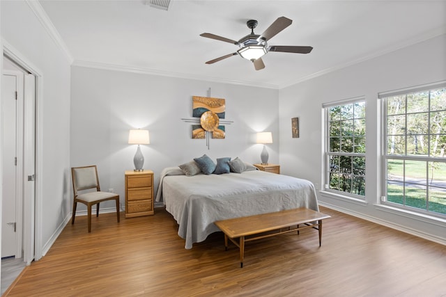 bedroom with light hardwood / wood-style flooring, ceiling fan, and crown molding