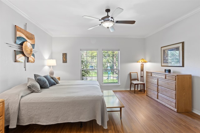 bedroom with ceiling fan, crown molding, and hardwood / wood-style flooring