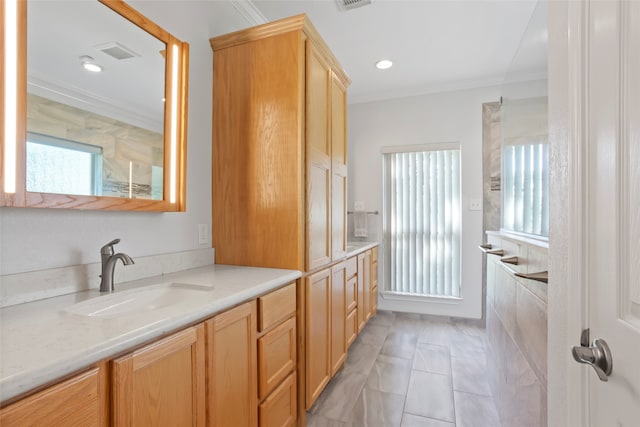 bathroom featuring vanity, a healthy amount of sunlight, and crown molding