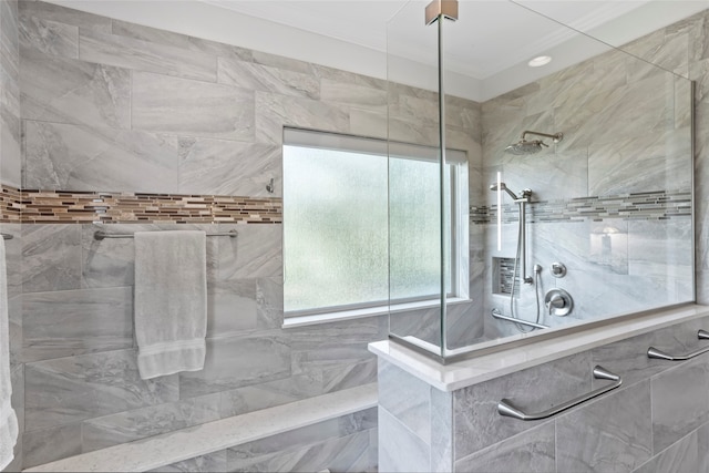 bathroom featuring ornamental molding and tiled shower