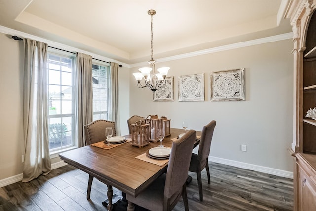 dining space with an inviting chandelier, ornamental molding, dark wood-type flooring, and a tray ceiling