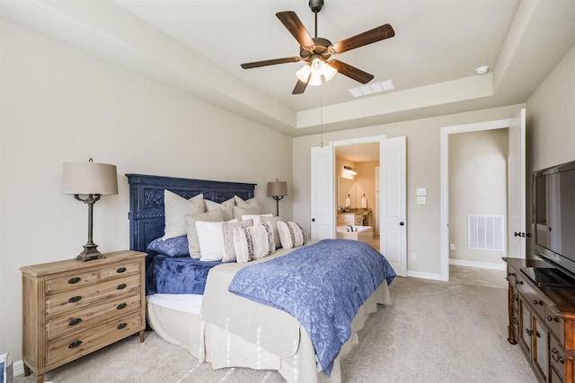 bedroom with a raised ceiling, ceiling fan, and light carpet