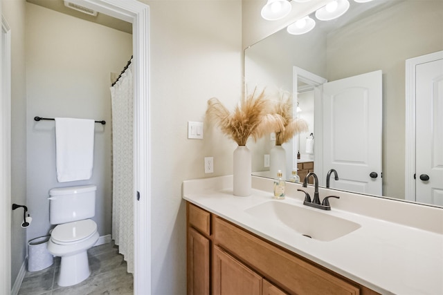 bathroom with tile patterned flooring, vanity, and toilet