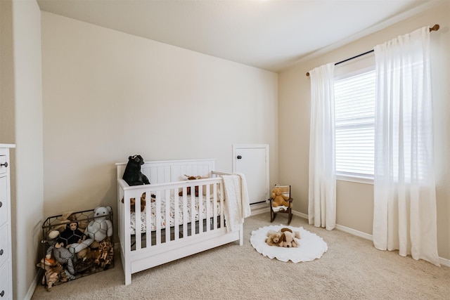 carpeted bedroom featuring a crib