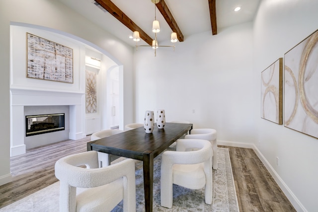 dining space with beamed ceiling and light hardwood / wood-style floors