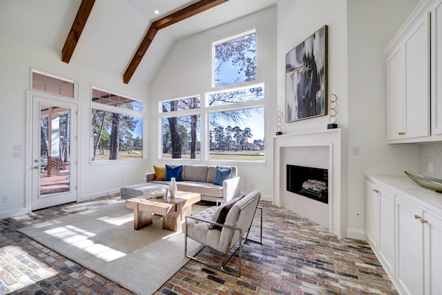 living room featuring beamed ceiling, high vaulted ceiling, and plenty of natural light