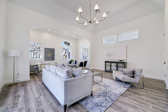 living room featuring wood-type flooring and an inviting chandelier