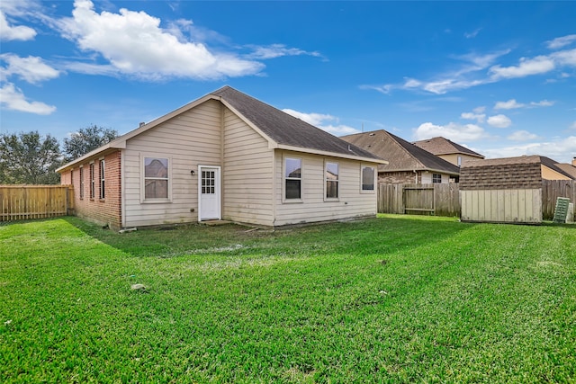 back of property featuring a lawn and a shed