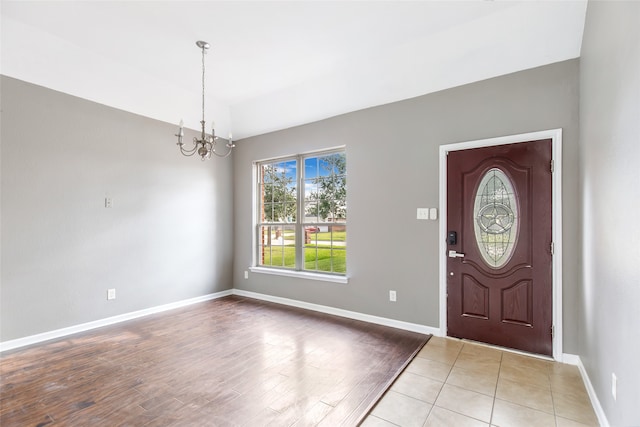 foyer with light hardwood / wood-style floors and a notable chandelier