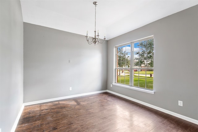 unfurnished room featuring dark hardwood / wood-style flooring and a chandelier